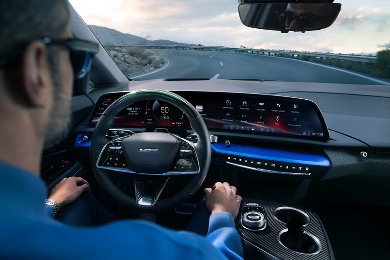 Front View of the 2026 OPTIQ-V Driving Through the Dusk Utilizing its Headlights | Otto Cadillac in Albany NY